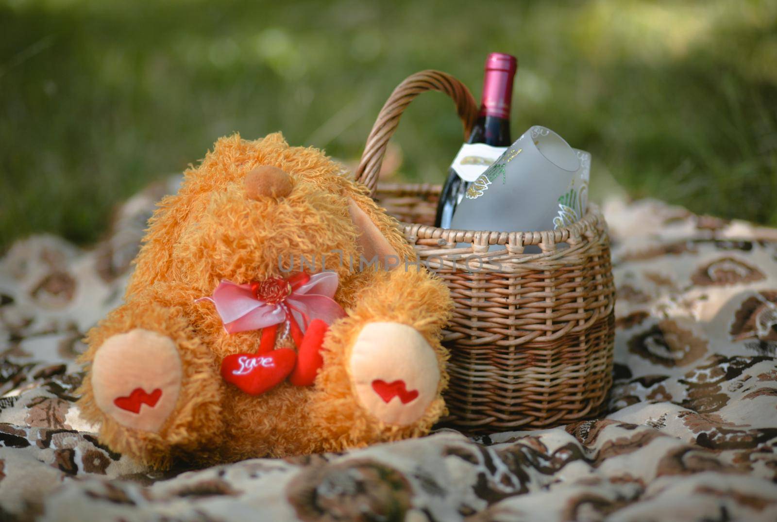 Wicker basket with picnic set. A bottle of wine and a Teddy bear by deandy