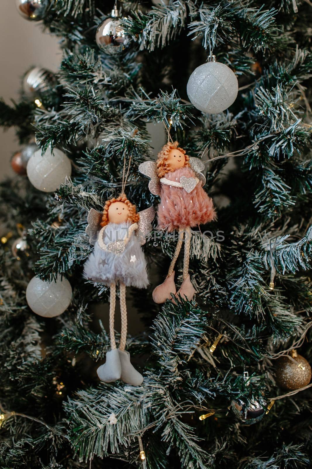 Christmas toys in the form of two little girls hanging on the tree