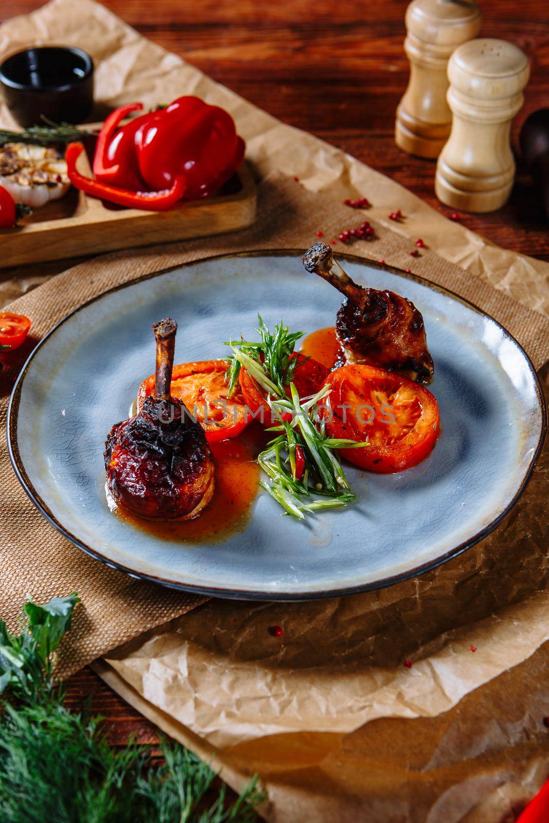 Fried quail legs with tomatoes on a plate, top view by deandy