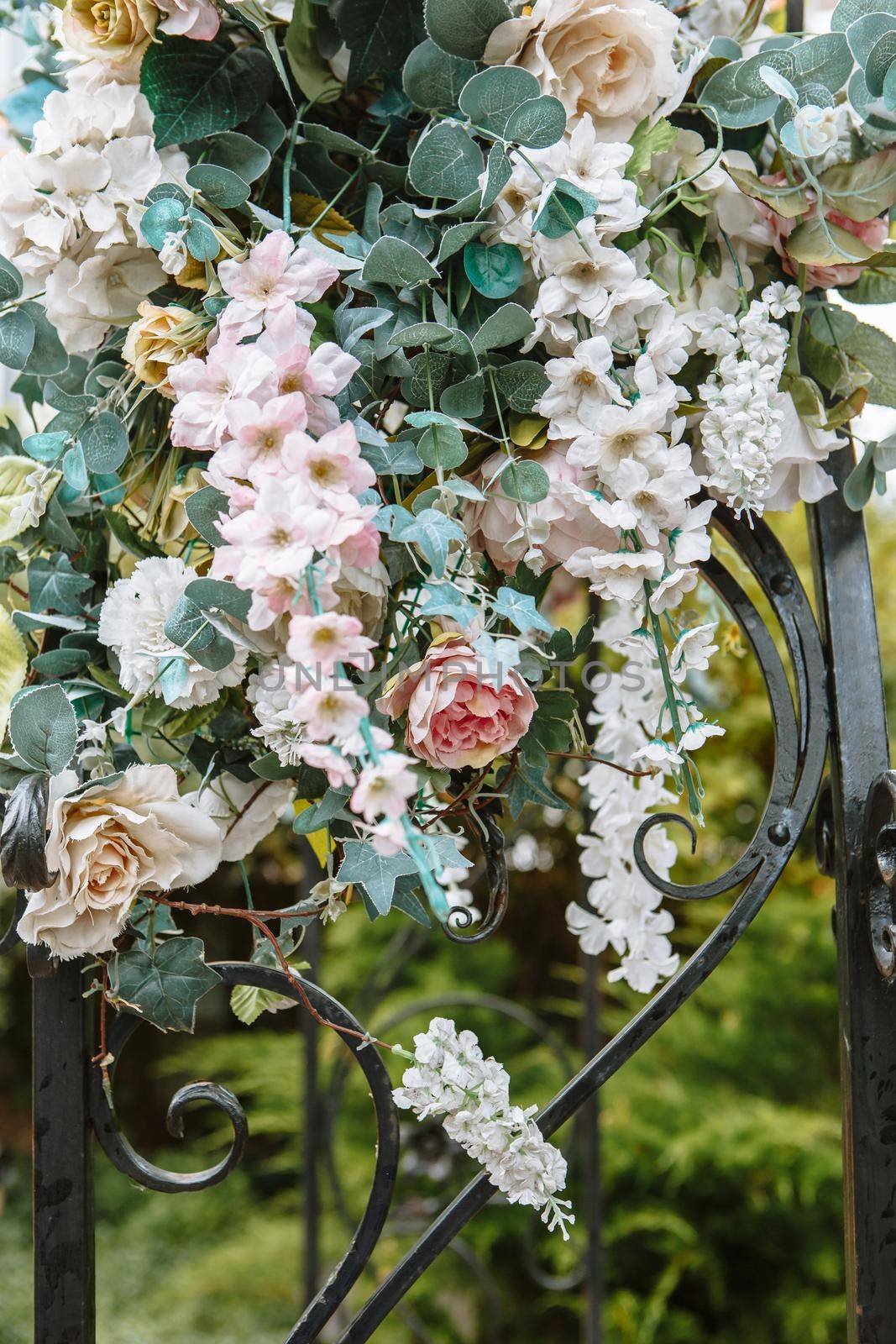 Decorative artificial flowers displayed on the street. Flowers are hanging on the bridge by deandy