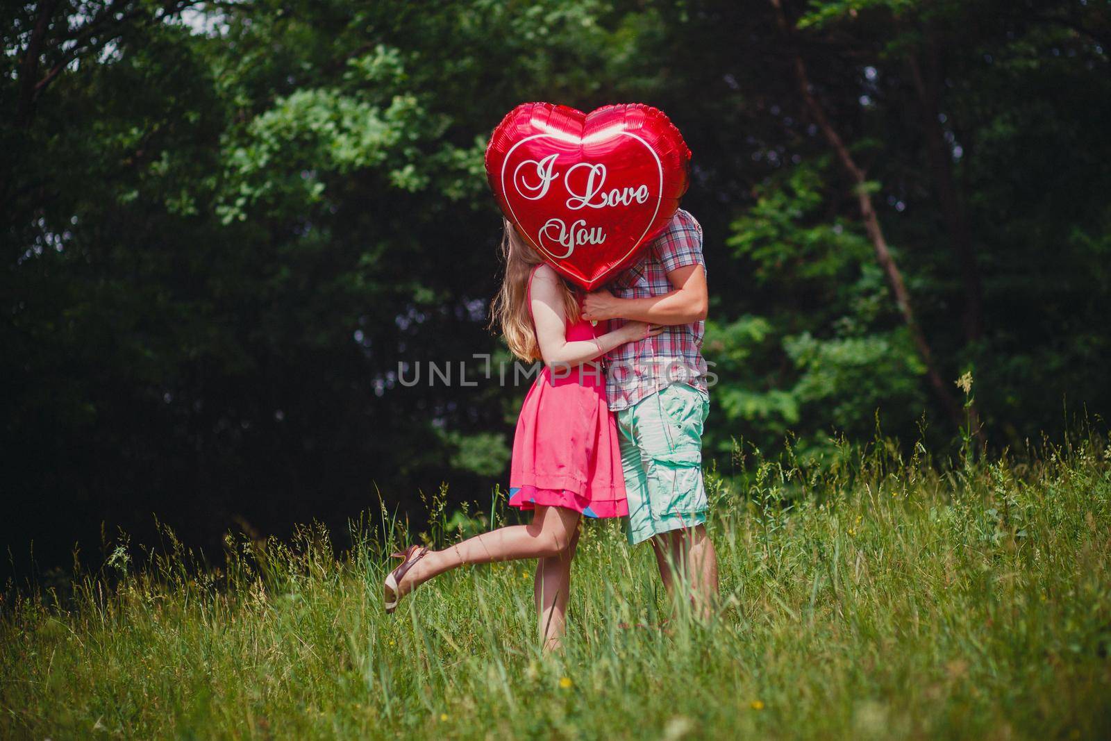 Young lovers hidden by helium balloons