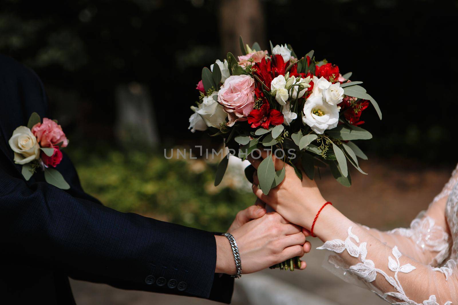 Beautiful wedding bouquet with colorful flowers. Transfer of the groom's bouquet to the bride.