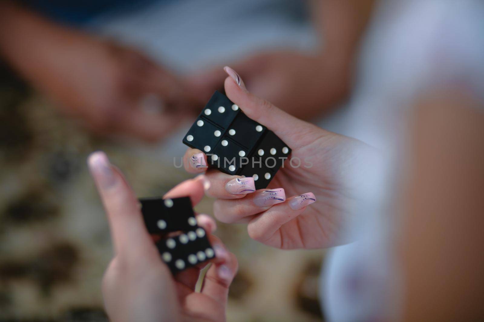 Hands of a girl with dominoes in a woman's hand, close-up