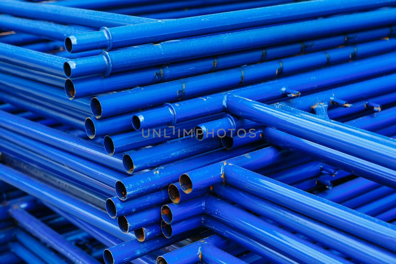 Blue pipes lying on top of each other. Scaffolding for building repairs by deandy