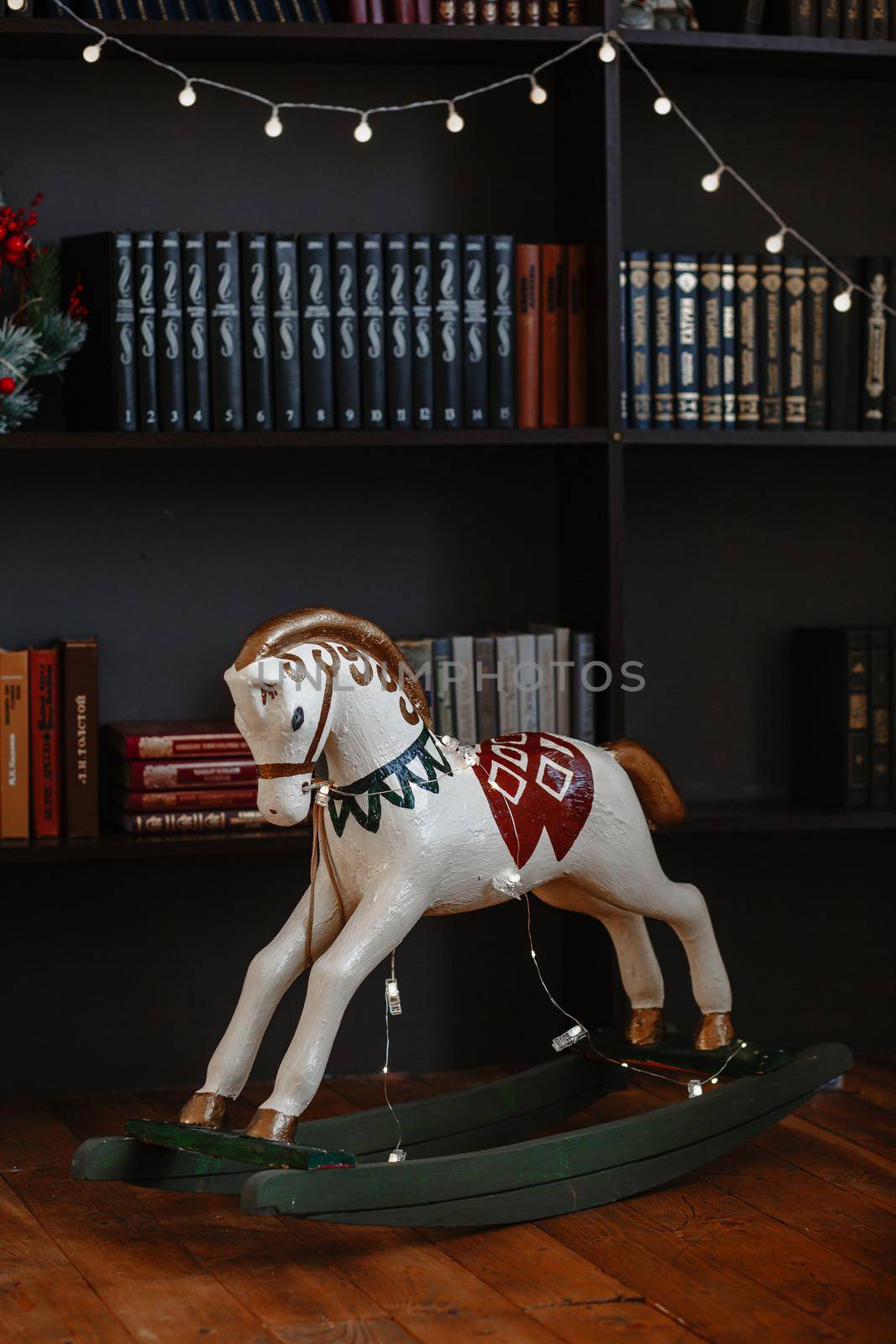 Children's toy horse standing next to a bookcase by deandy