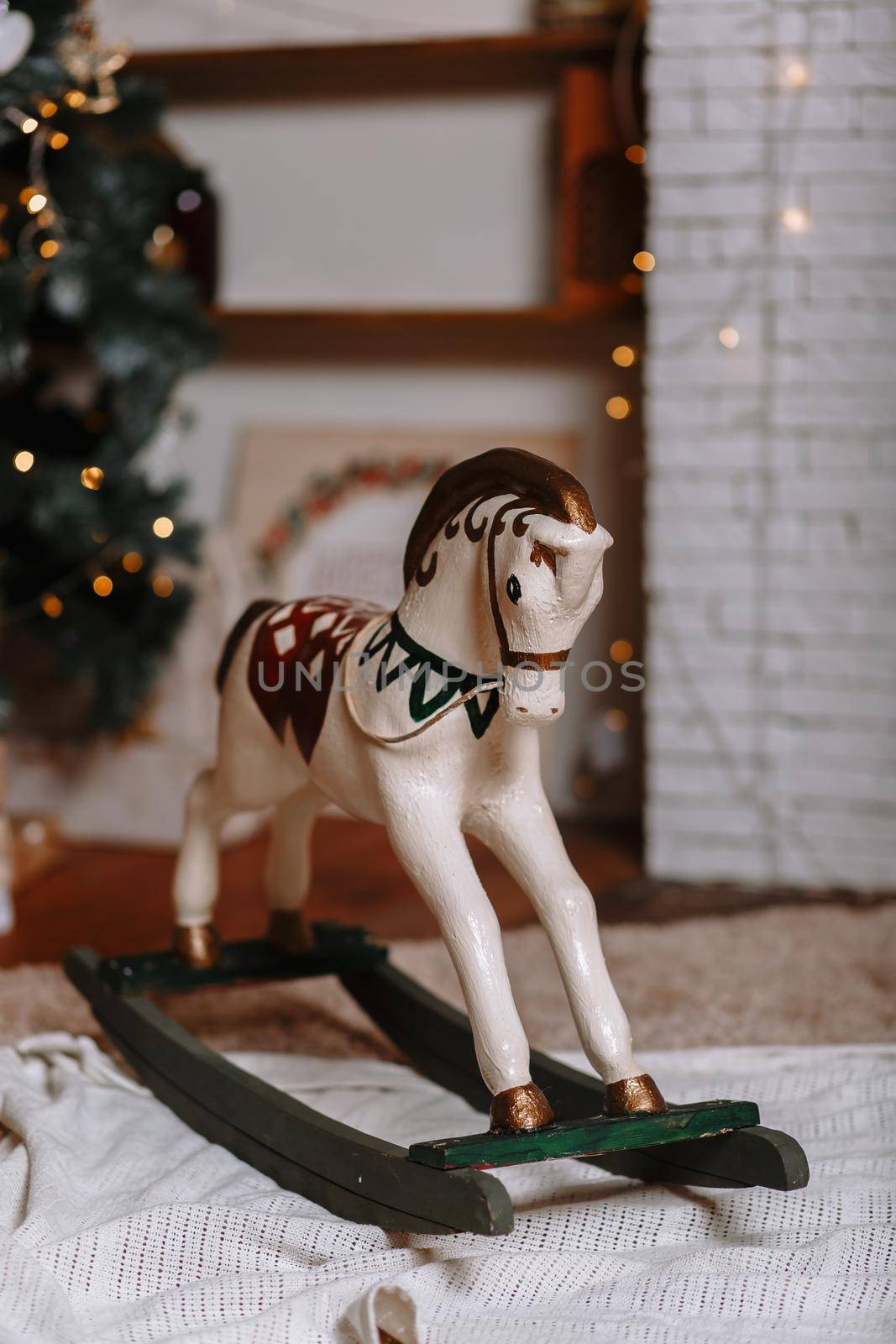 A horse, a swing toy, standing in a New Year's studio, against the background of a burning garland by deandy