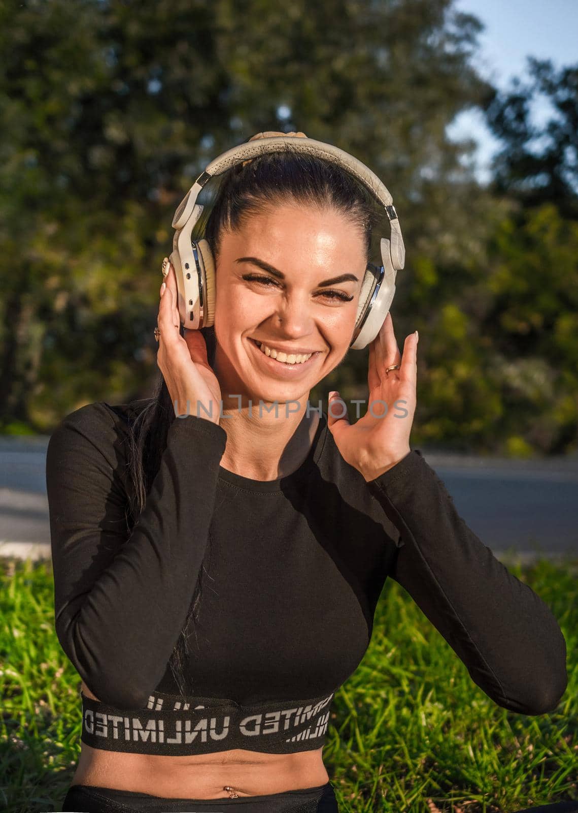 Smiling young woman with headphones outdoors enjoying music./Pretty young woman listening to music.