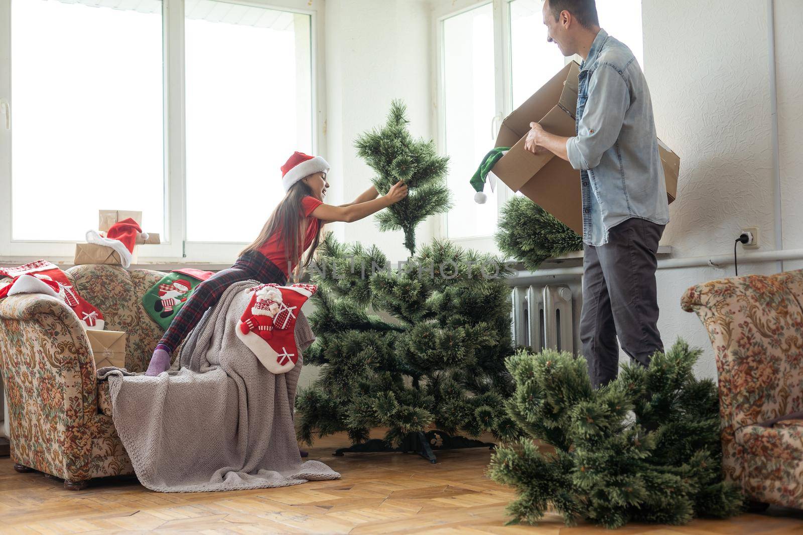 father and daughter install an artificial Christmas tree.