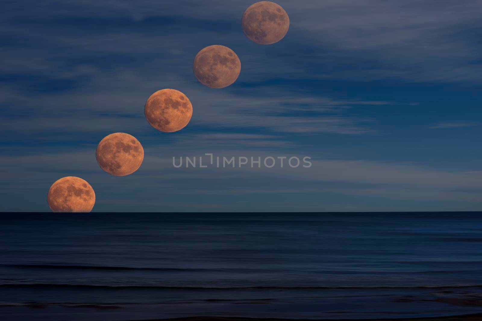 Photo of the moon rising over the sea. Illustration. calm water with moving effect, dark moving clouds, photo as a drawing