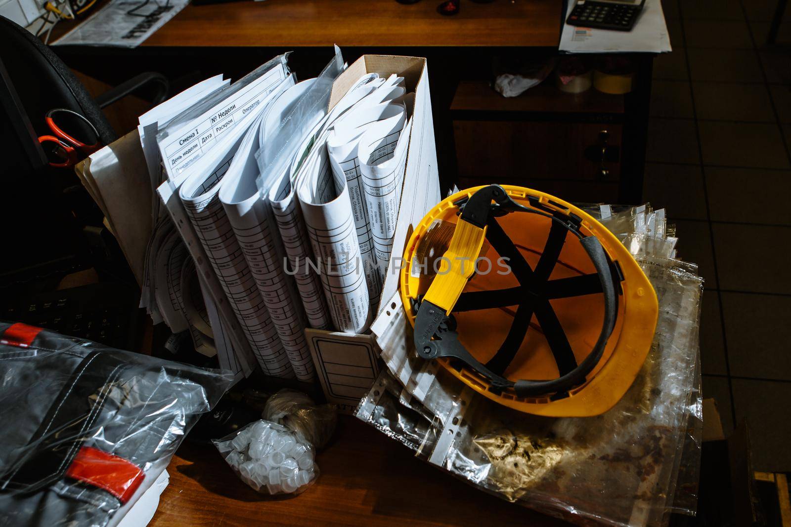 Yellow work helmet lying on a table with offic by deandy