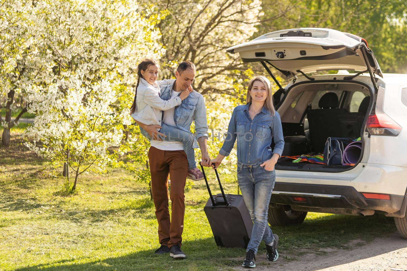 Family Enjoying. happy little girl with family near the car. Car insurance concept.