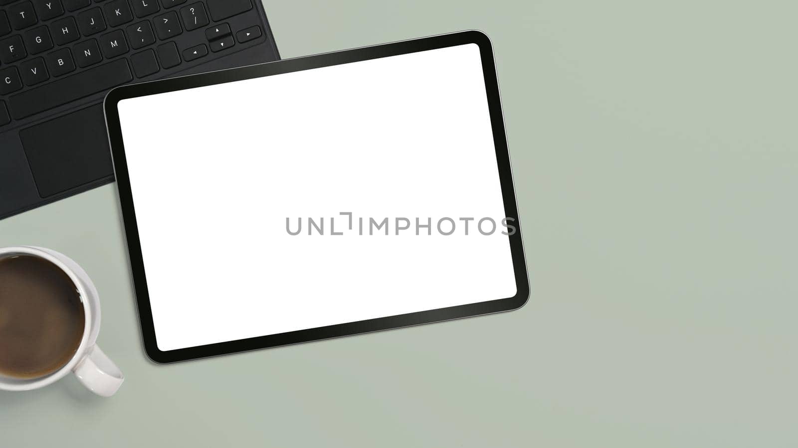 Flat lay digital tablet, coffee cup and laptop on green background by prathanchorruangsak