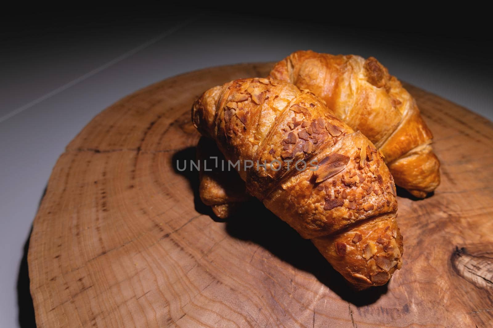 Close-up three a delicious croissant with almonds on a wooden pallet. Delicious and healthy breakfast by yanik88