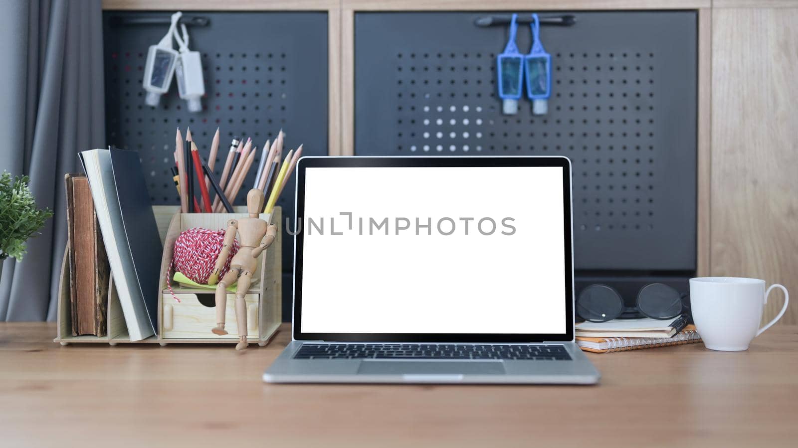 Front view mock up computer laptop with white screen on wooden table in home office. by prathanchorruangsak