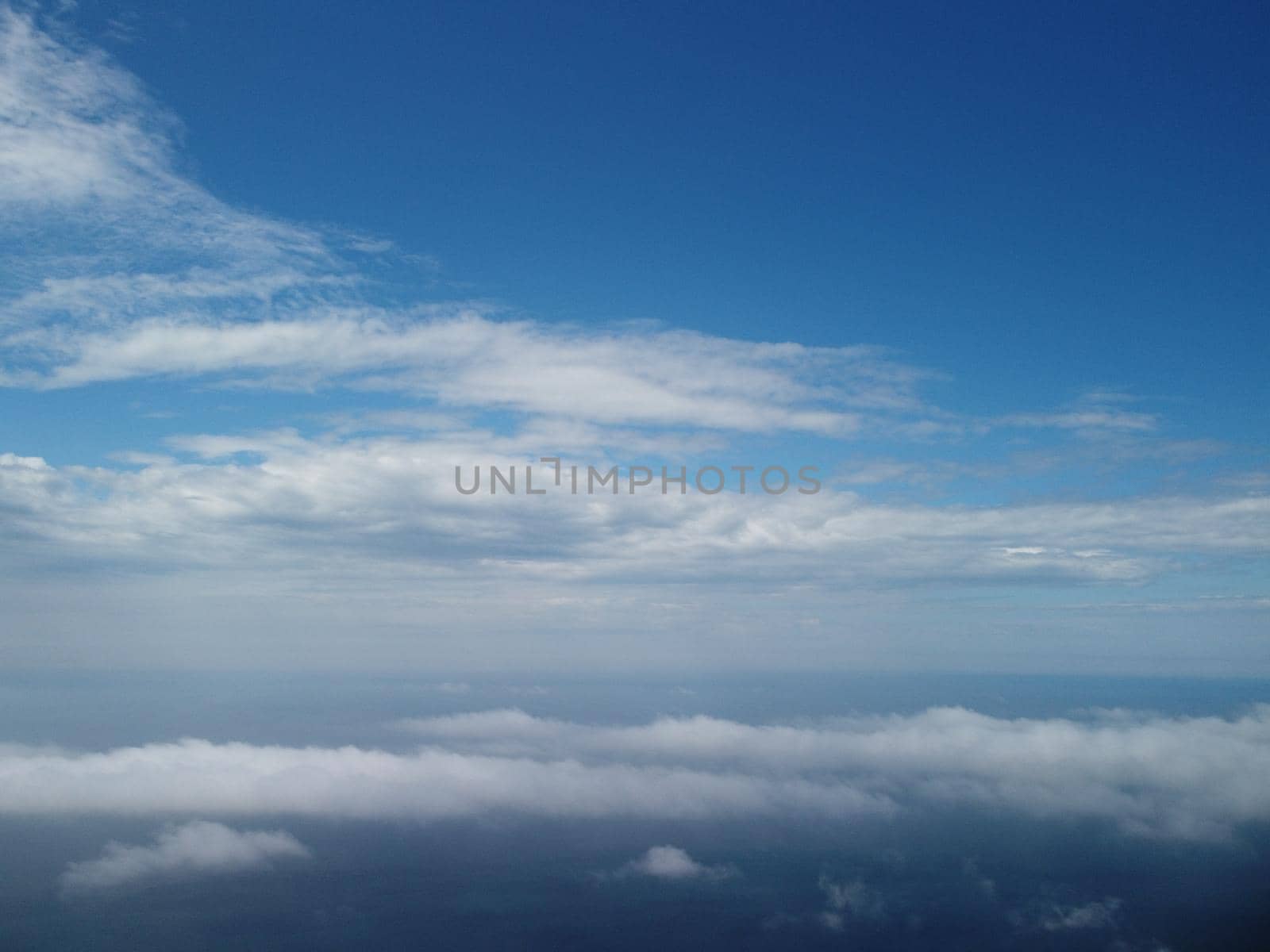 Aerial view. Blue sky sun and fog over calm sea. The drone flies over foggy and fluffy clouds. Abstract aerial nature summer ocean sunset sea and sky background. Vacation, travel and holiday concept. by panophotograph