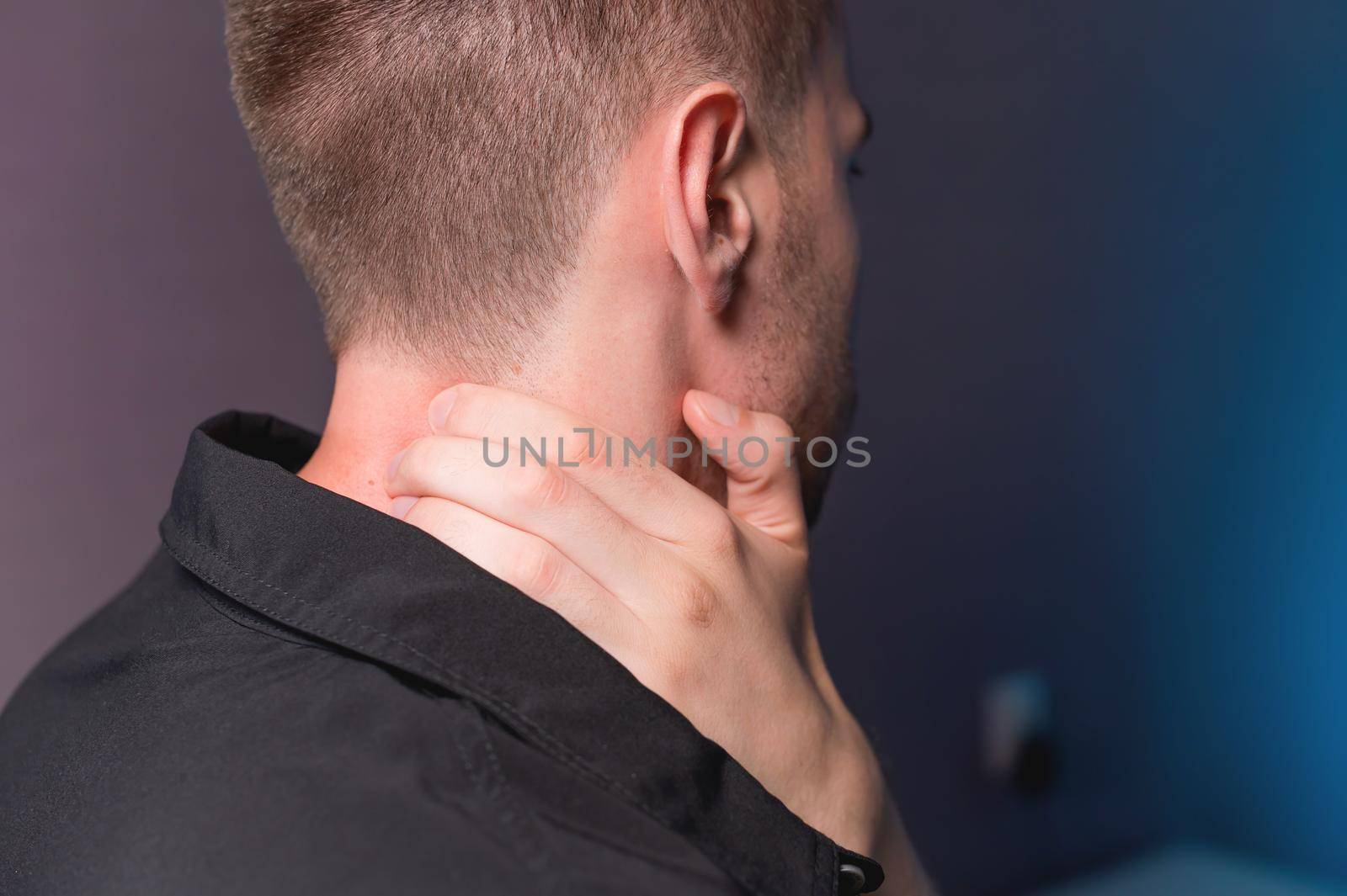 Close-up of a man independently kneading his neck and neck muscles long extensors of the neck. Neck pain.