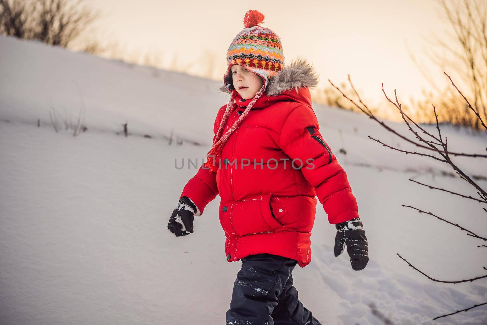 Cute boy in red winter clothes runs fun in the snow. Winter Fun Outdoor Concepts.