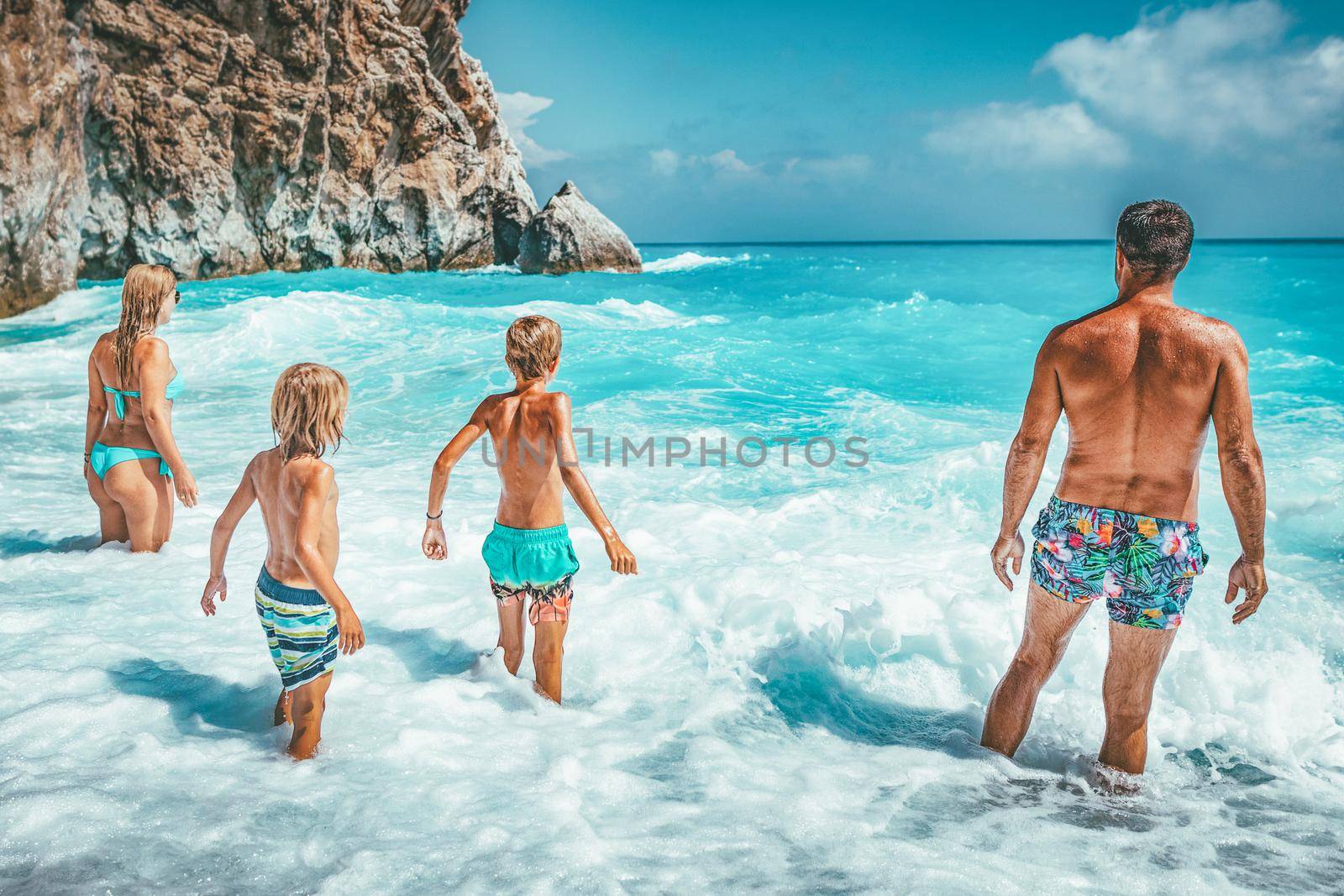 Young family on vacation have a lot of fun in a sea waves.