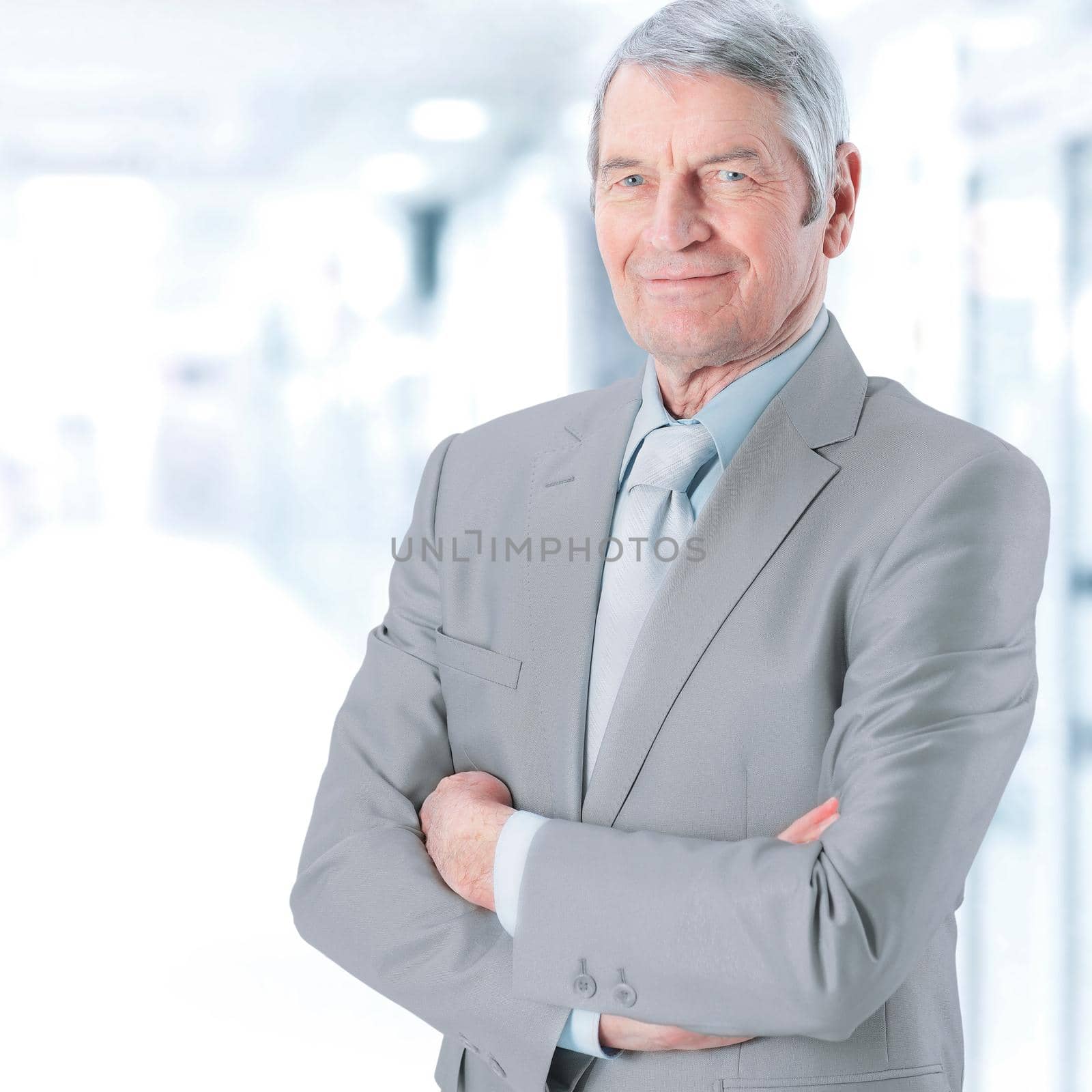 portrait of a successful, experienced businessman on blurred background by SmartPhotoLab