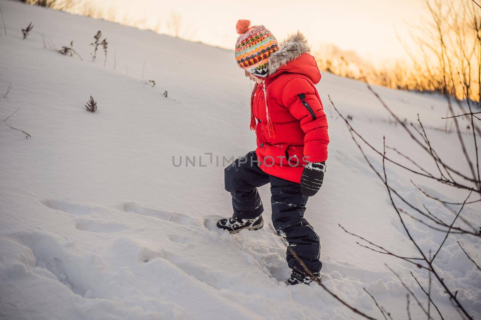 Cute boy in red winter clothes runs fun in the snow. Winter Fun Outdoor Concepts.