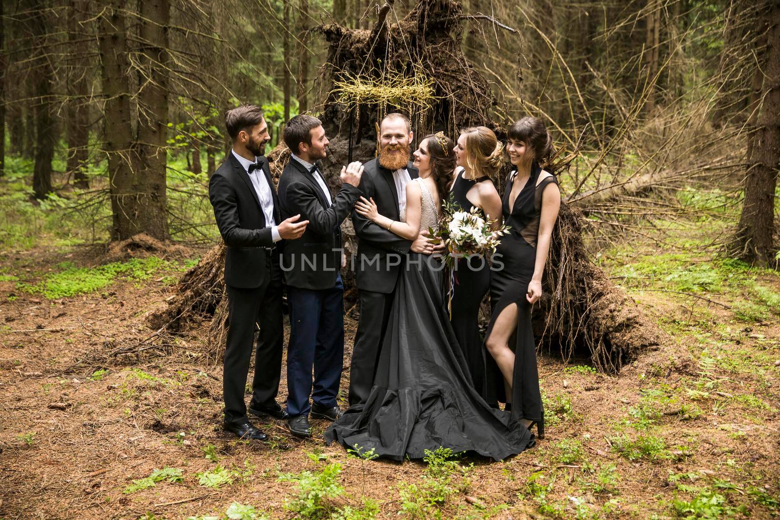 portrait of the couple and the witnesses in the background of a hut in the woods by SmartPhotoLab