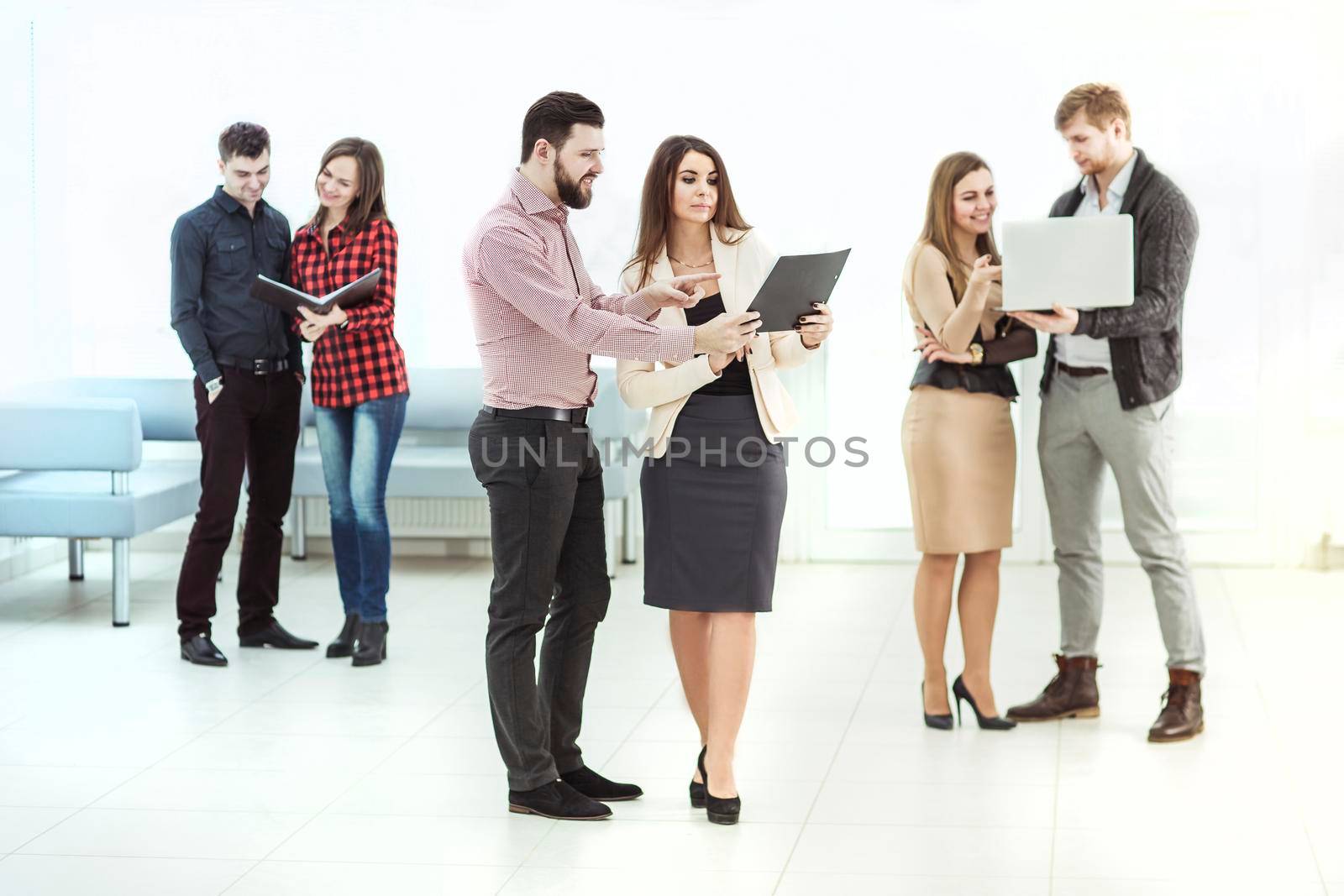 business team with laptop and documents standing in the lobby of the office before a business meeting