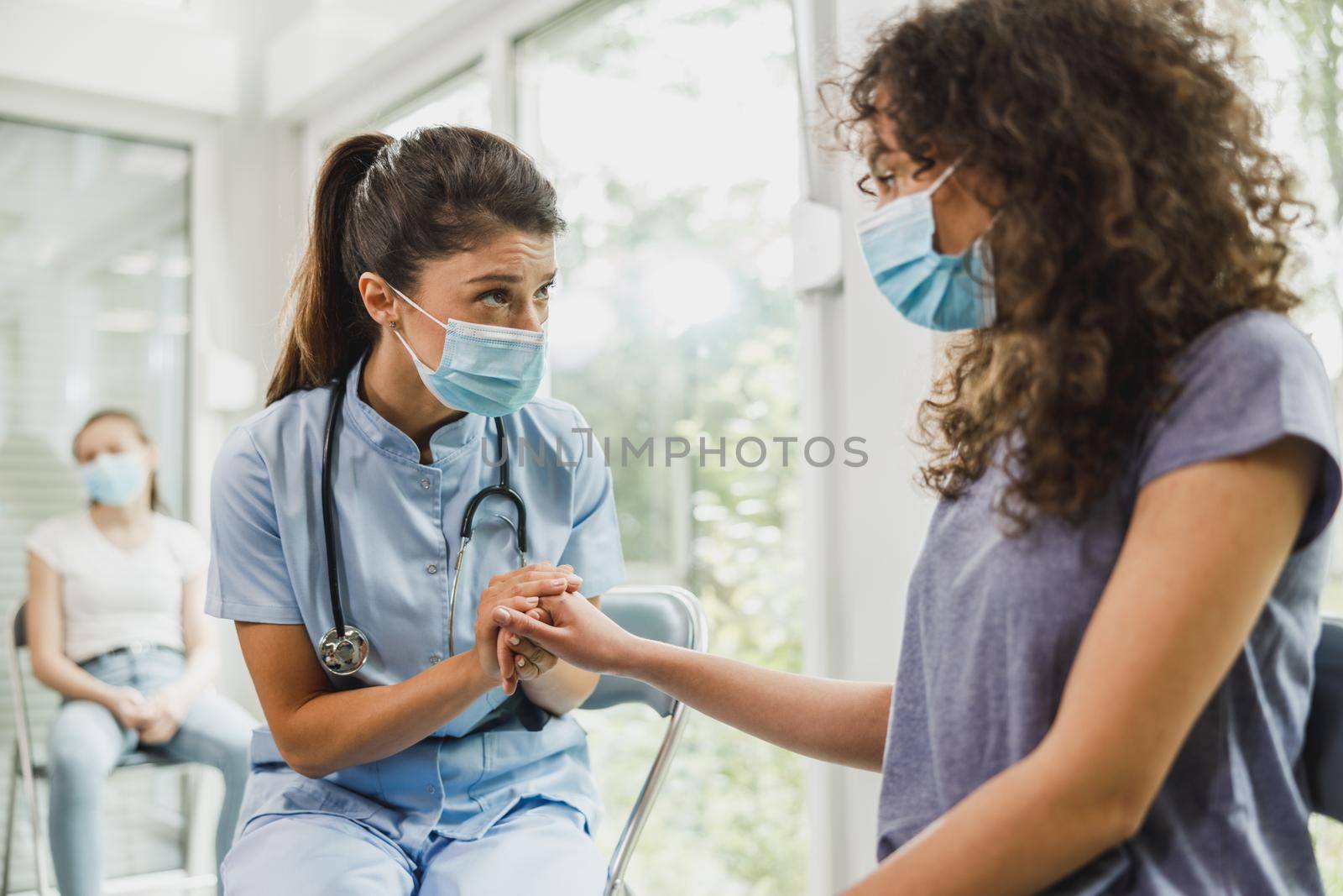 Nurse talking to African American female teenager and taking notes before vaccination against coronavirus.