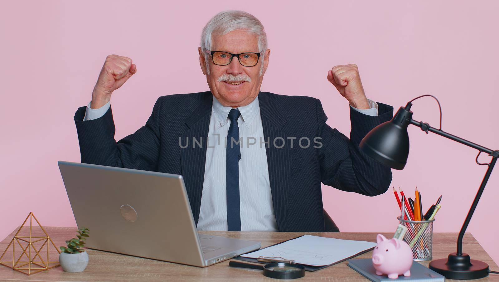 I am strong and independent. Senior office businessman showing biceps, looking confident, feeling power strength to fight for rights, energy to gain success win. Elderly man on pink studio background