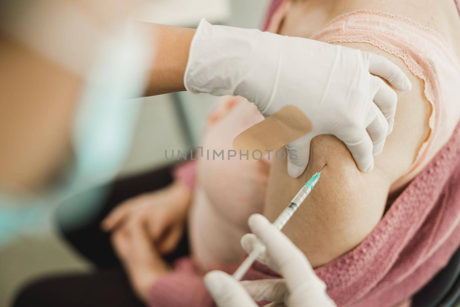 Close-up of a senior woman receiving a vaccine due to coronavirus pandemic.