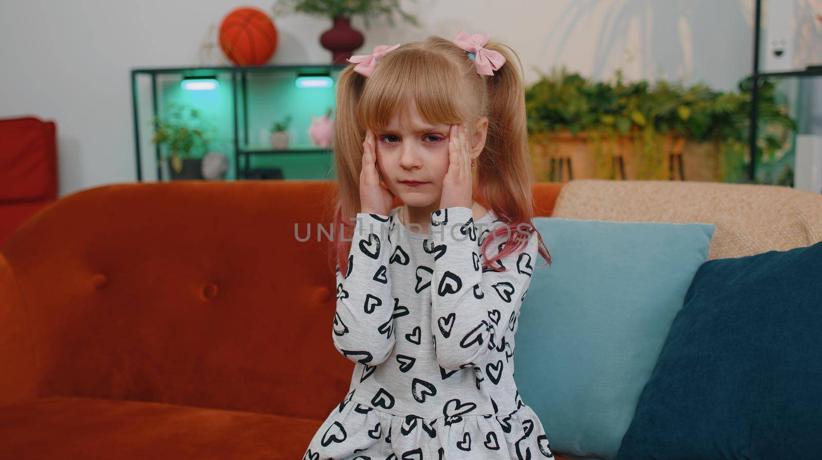 Portrait of displeased little teen child girl rubbing temples to cure headache problem, suffering from tension and migraine, stress, grimacing in pain, feeling bad sick, ill. Toddler kid at home alone