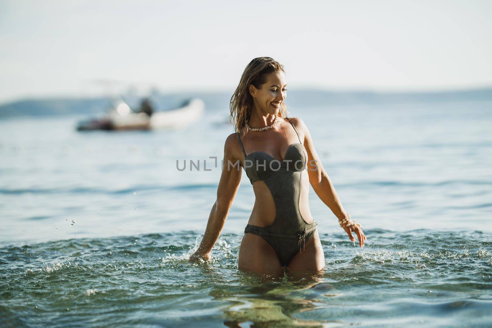 A beautiful young woman relaxing in the sea water and enjoys on a summer vacation.
