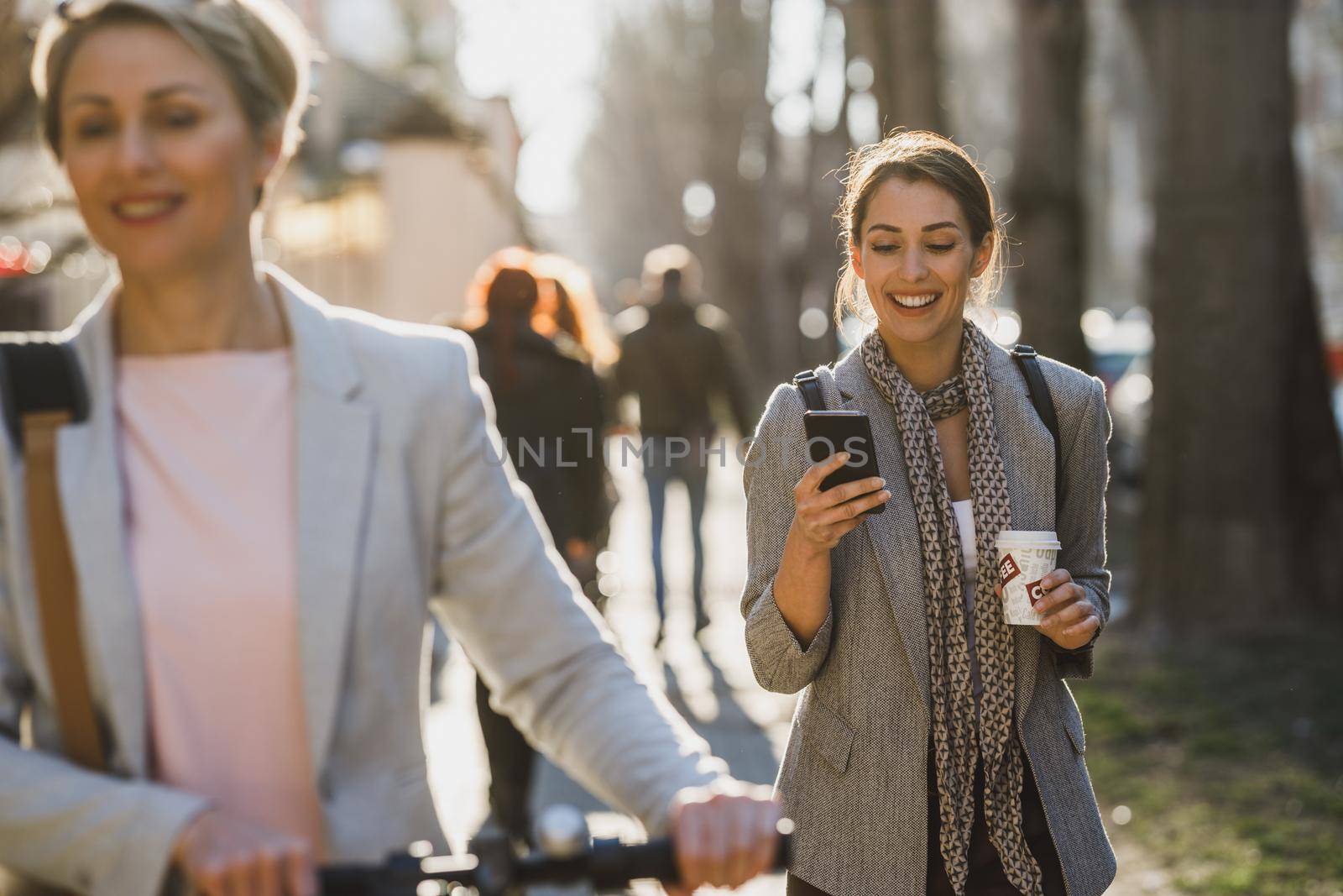 A young businesswoman using a smartphone while going to work.