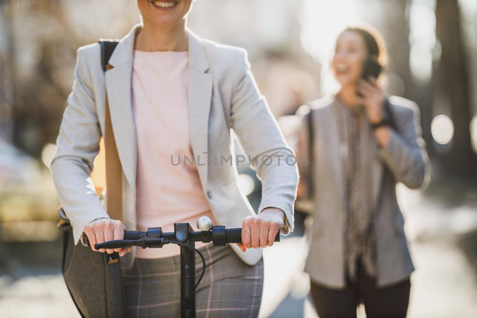 Shot of an unrecognisable businesswoman riding an electric scooter on her way to work.