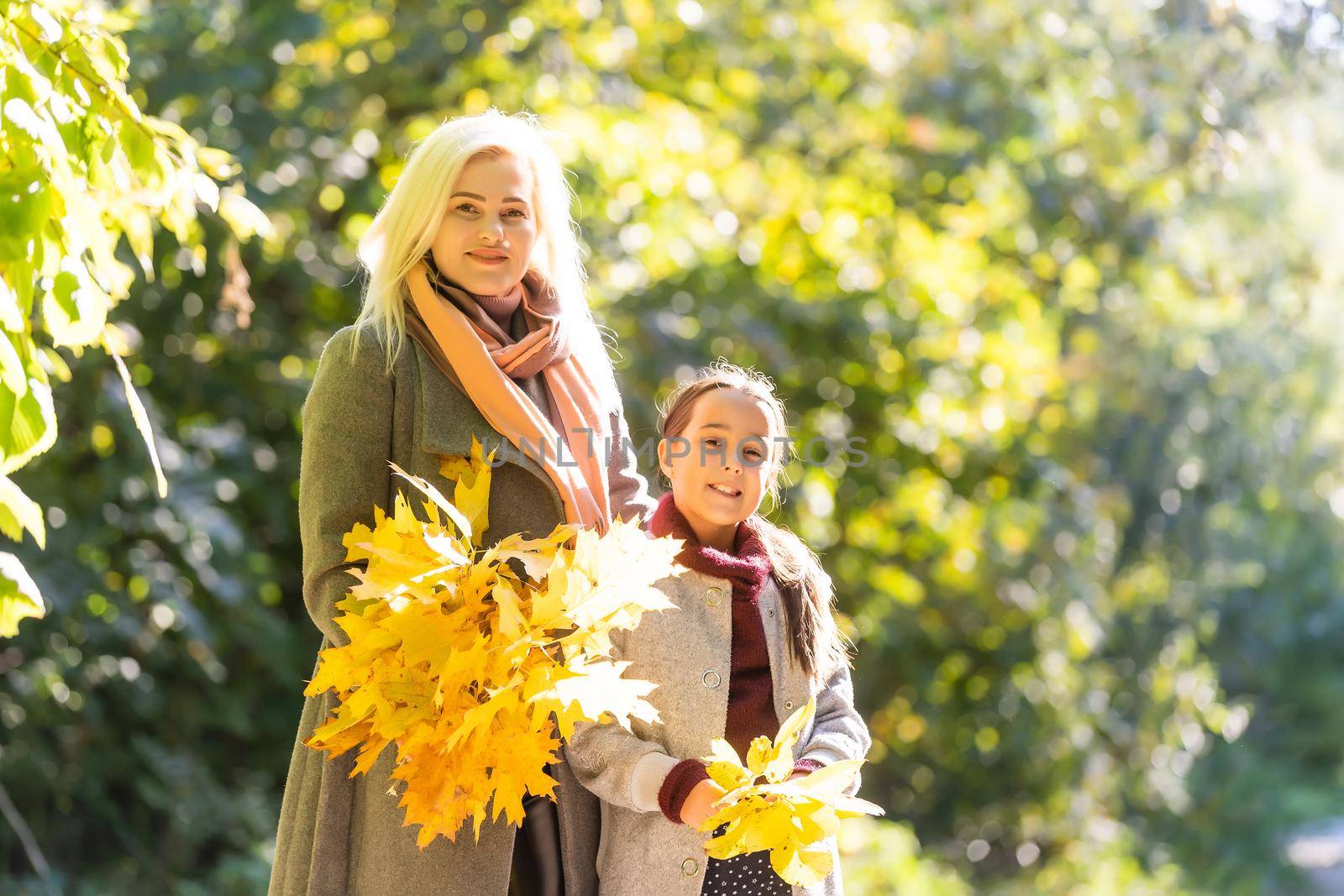 Mom with her daughter during autumn.