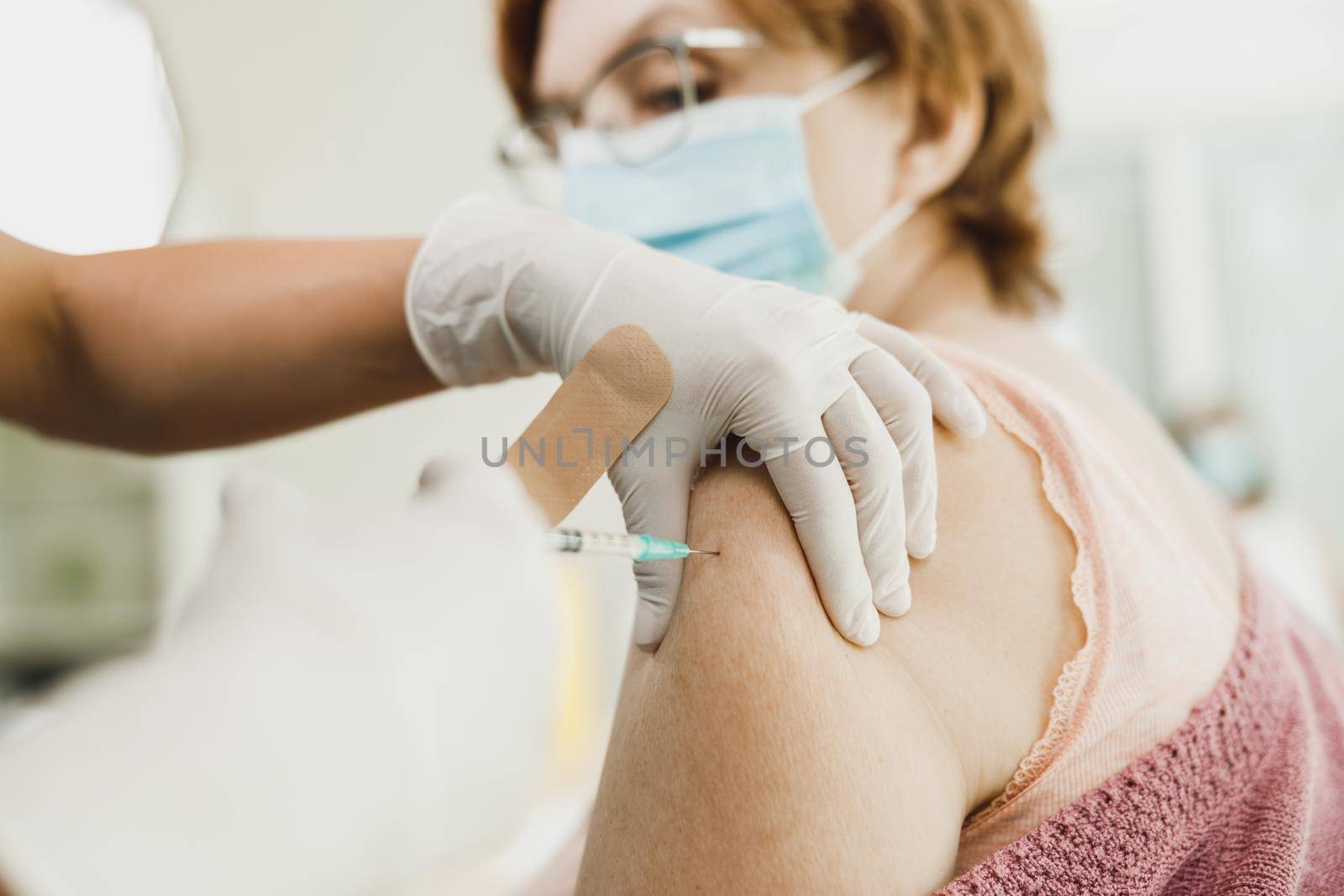Close-up of a senior woman receiving a vaccine due to coronavirus pandemic.