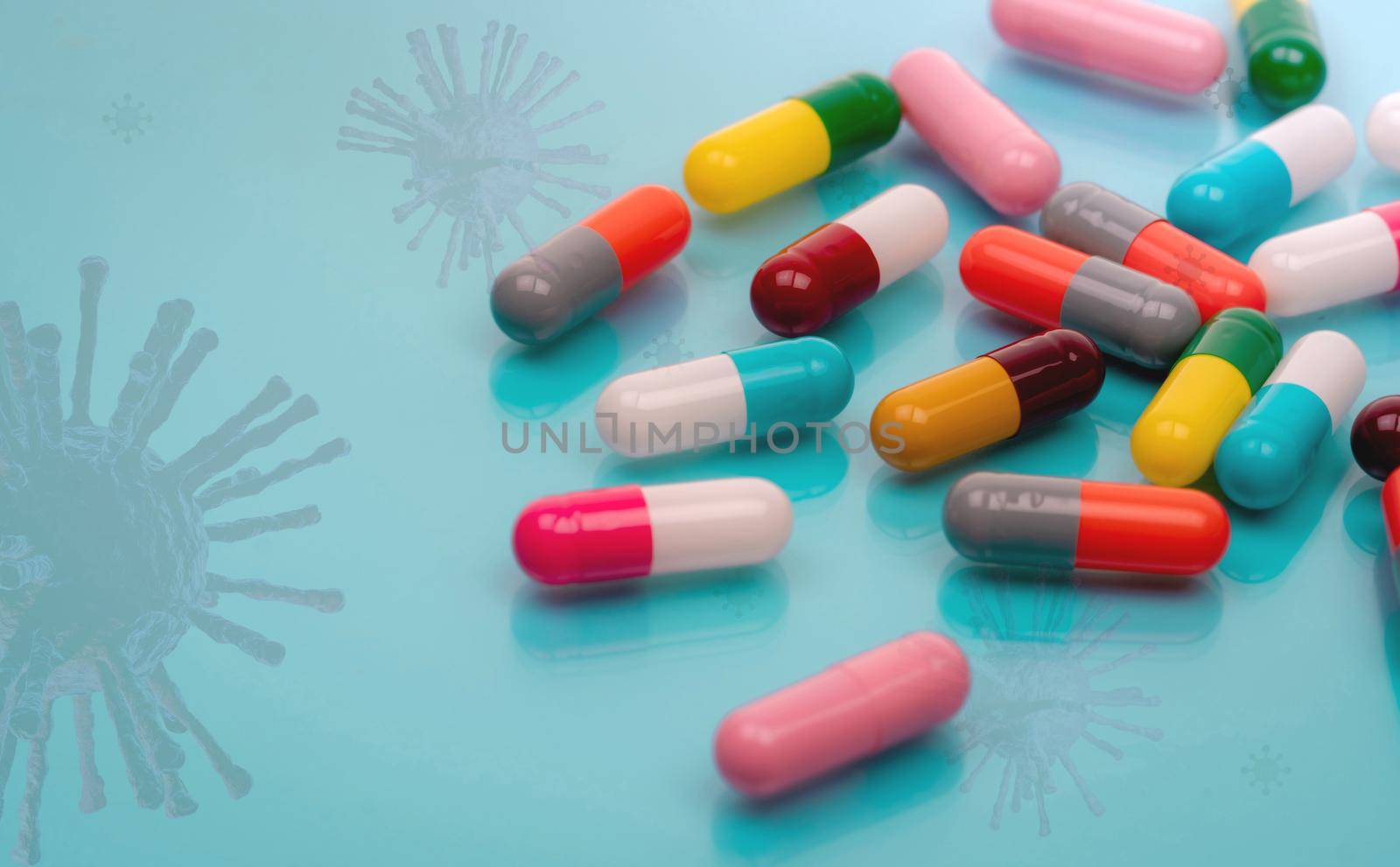 Antiviral capsule pills with virus on blue background. Drug development and new drug research for treatment emerging infectious diseases. Prescription drugs. Pharmaceutical industry. Pharmacology.