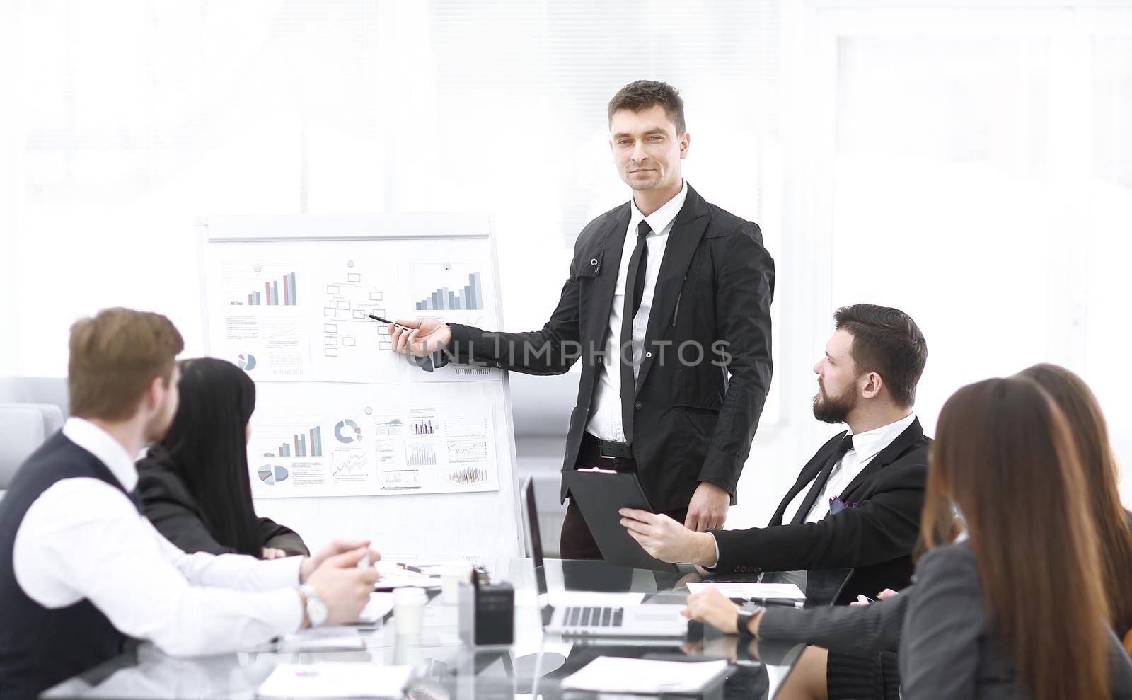 Finance Manager pointing a marker on the flipchart with financial data.