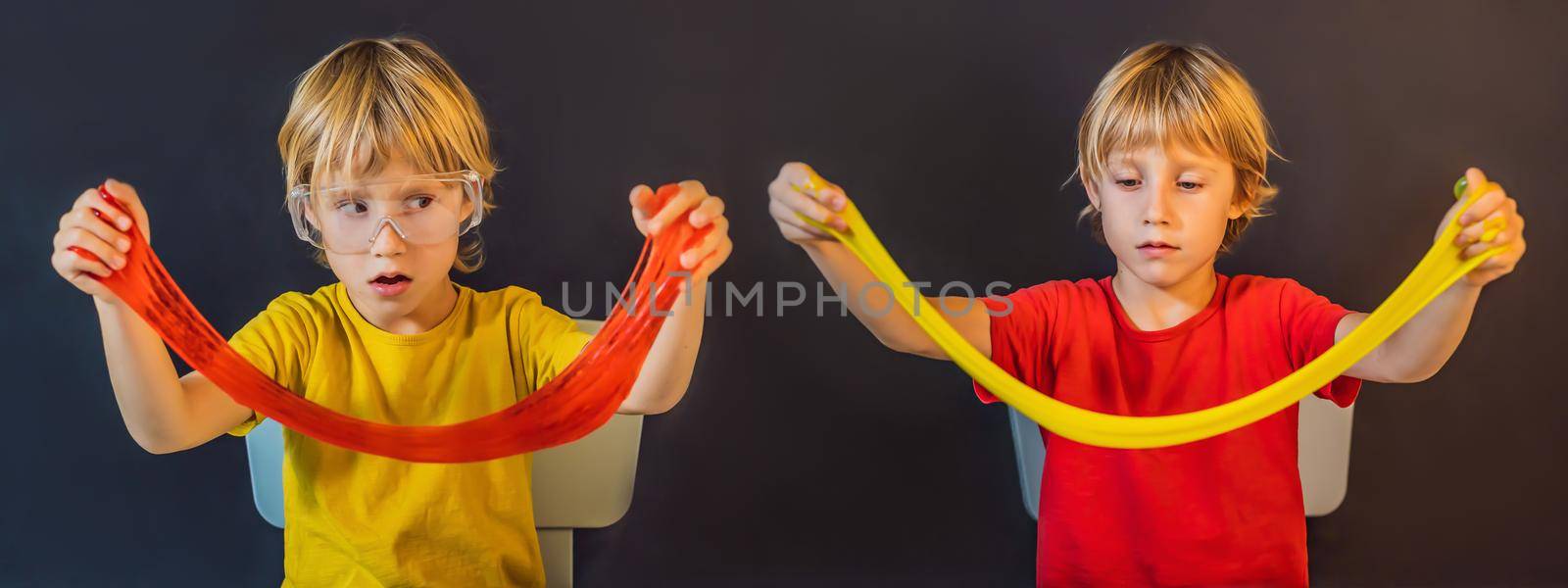 Two twin brothers play with hand made toy called slime. Children play with slime. Kids squeeze and stretching slime by galitskaya