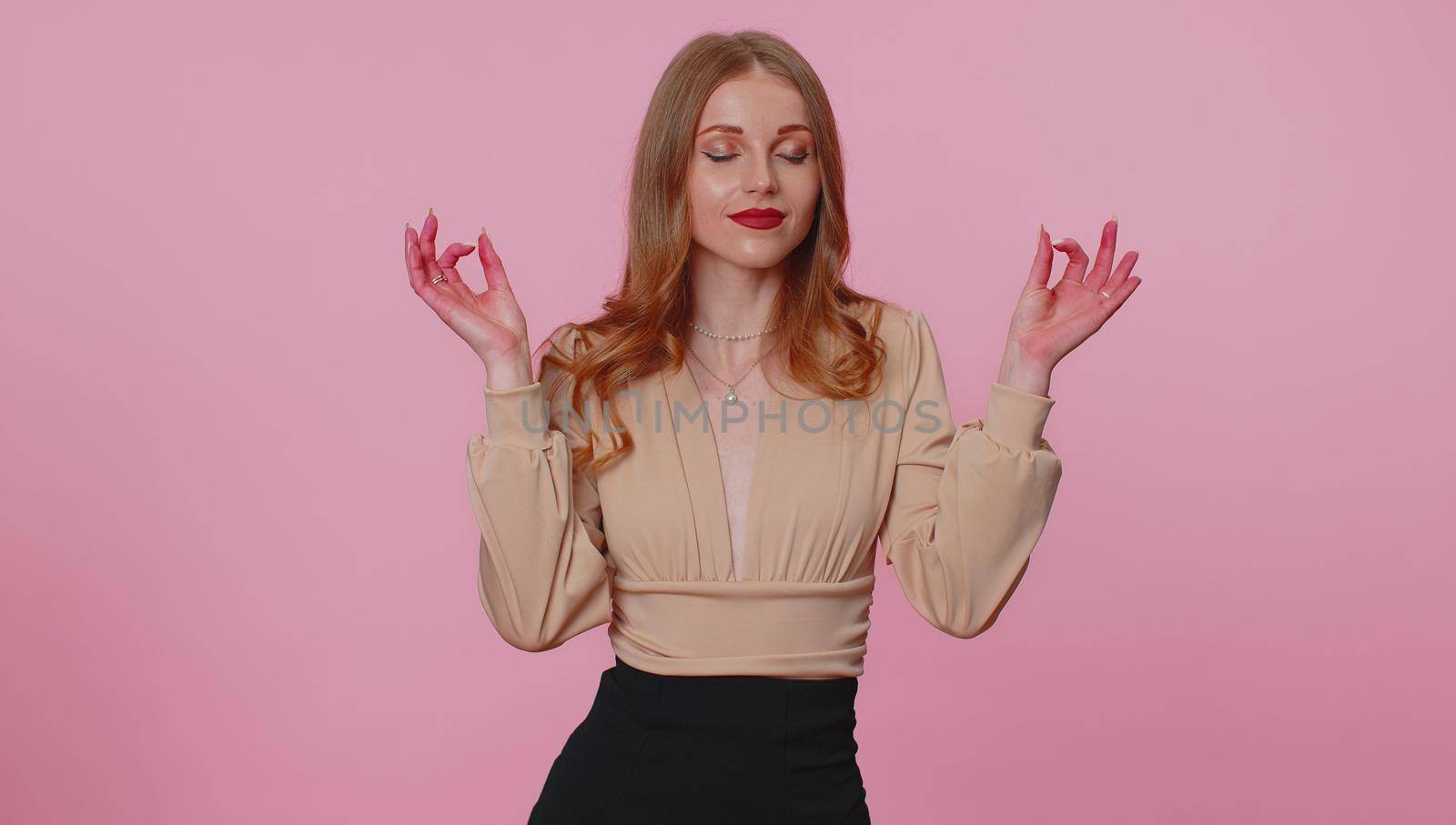 Keep calm down, relax, inner balance. Pretty businesswoman girl breathes deeply with mudra gesture, eyes closed, meditating with concentrated thoughts, peaceful mind. Woman on pink studio background