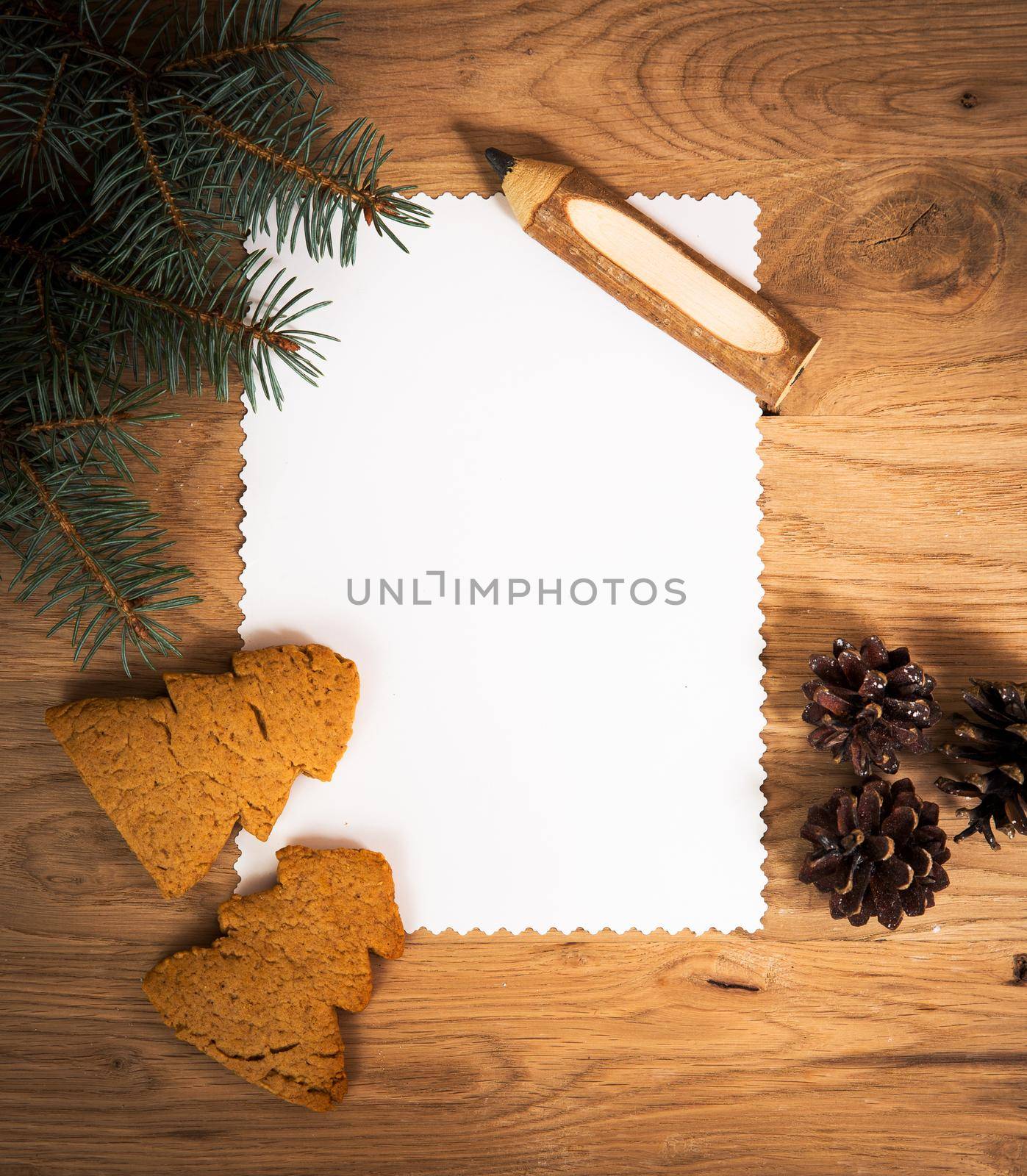 blank sheet of paper on the wooden floor with a pencil and Christmas decorations