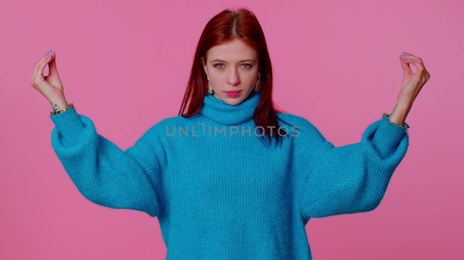 Keep calm down, relax, inner balance. Pretty redhead teen girl breathes deeply with mudra gesture, eyes closed, meditating with concentrated thoughts, peaceful mind. Woman on pink studio background