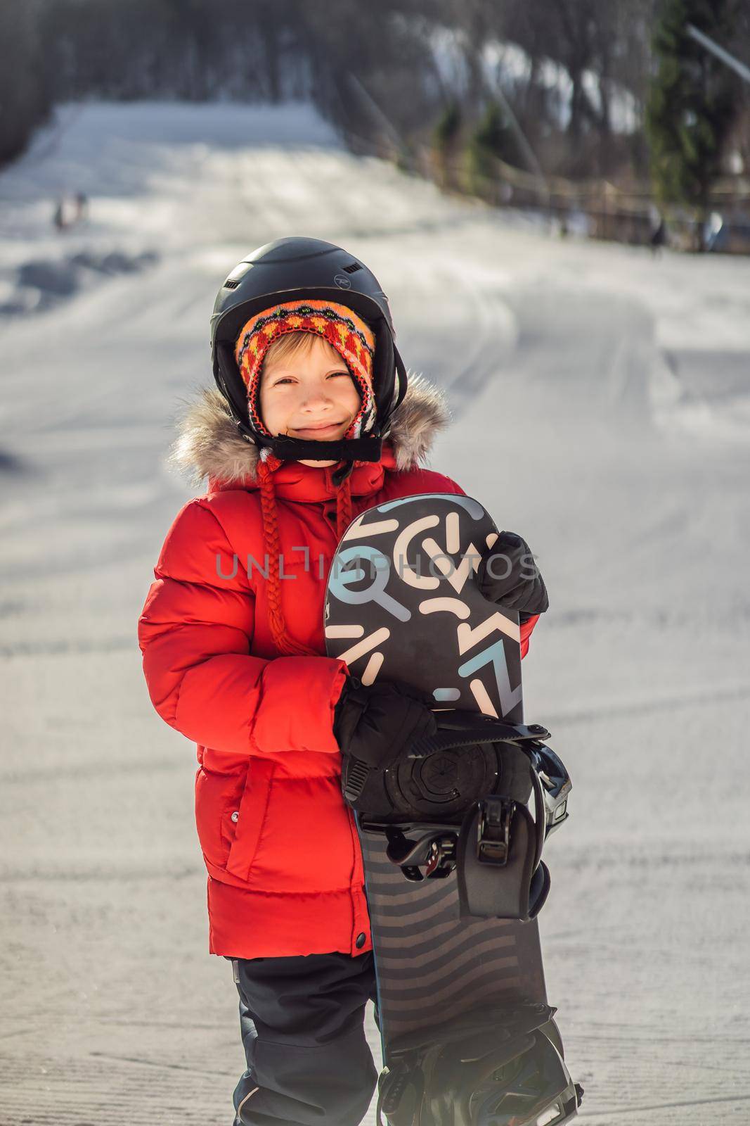 Little cute boy is ready for snowboarding. Activities for children in winter. Children's winter sport. Lifestyle.