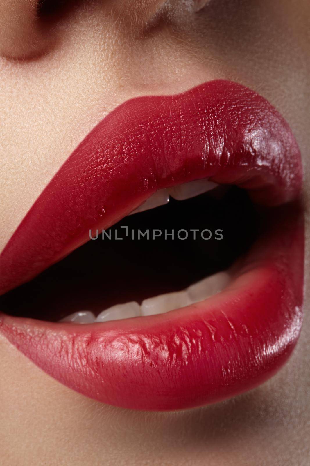 Close-up of woman's lips with fashion red make-up. Beautiful female mouth, full lips with perfect makeup. Classic visage. Part of female face. Macro shot of beautiful make up on full lips.