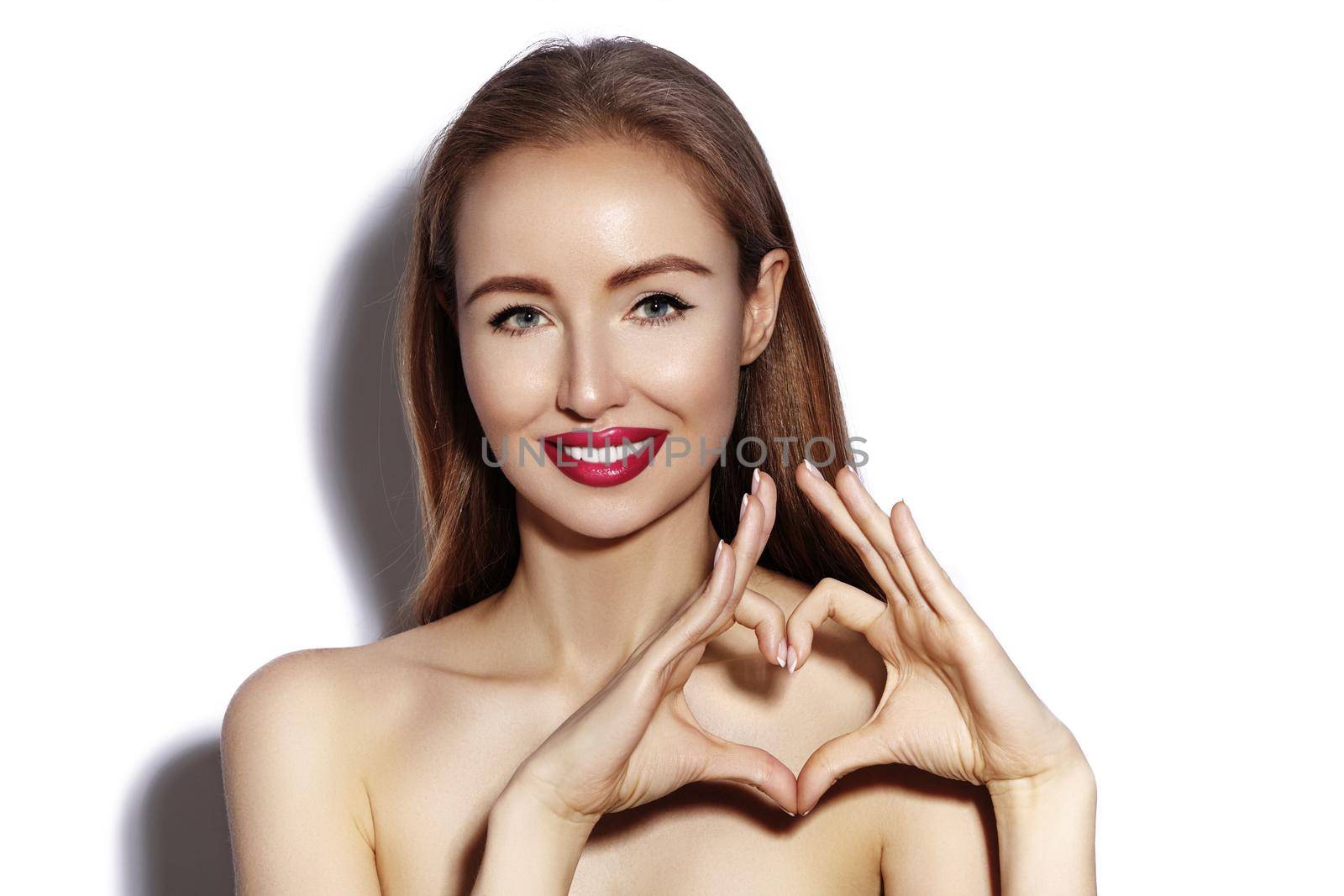 Romantic young Woman making Heart Shape with her Fingers. Love and Valentines Day Symbol. Fashion girl with Happy Smile by MarinaFrost