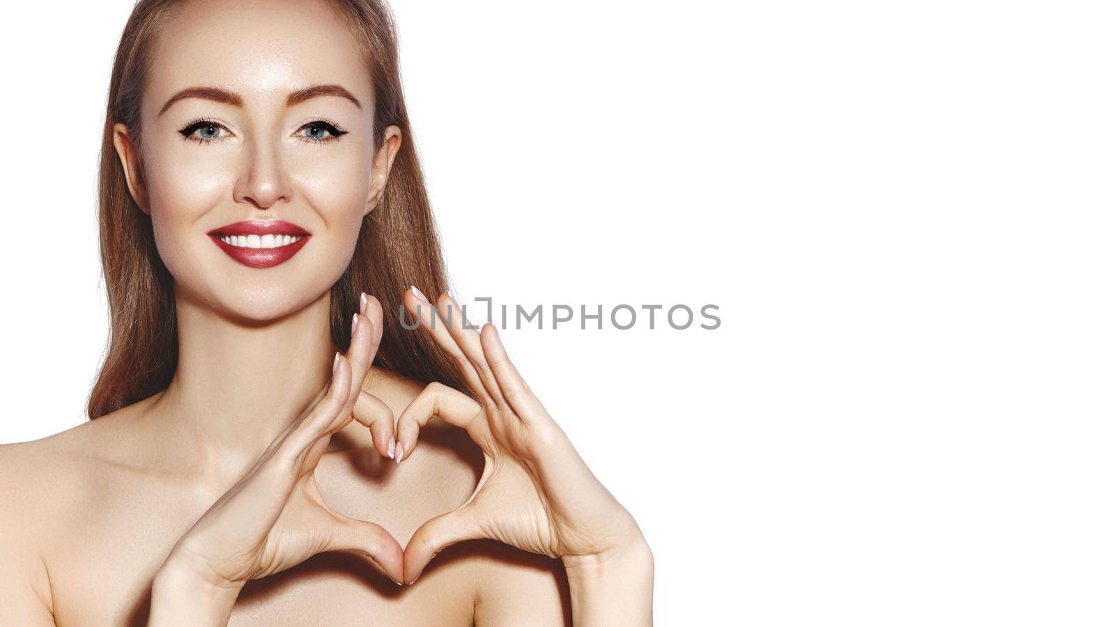 Romantic young Woman making Heart Shape with her Fingers. Love and Valentines Day Symbol. Fashion girl with Happy Smile on white background.