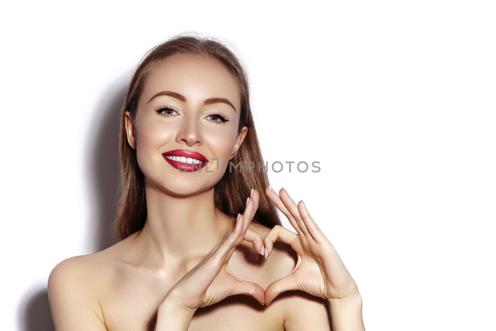 Romantic young Woman making Heart Shape with her Fingers. Love and Valentines Day Symbol. Fashion girl with Happy Smile on white background.