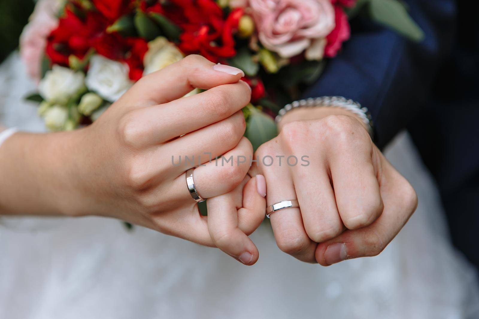 The hands of the newlyweds, who are holding on to the little fingers by deandy