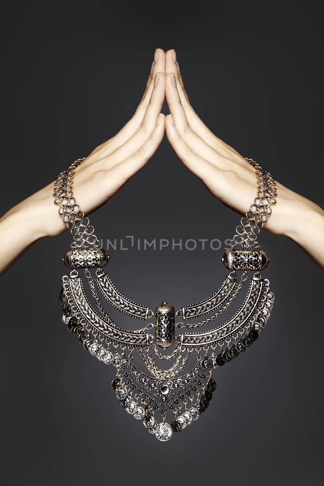 Silver necklace jewelry in woman hands. Beautiful fashion accessories. Luxury gift, Tibet silver jewellery on grey background
