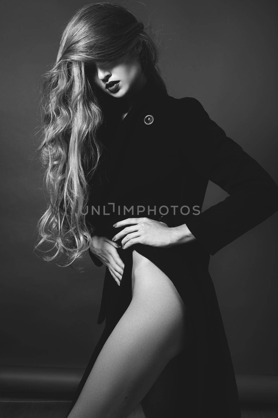 Sexy lady in Elegant Coat. Beautiful model in Fashion Jacket with Long Curly Hair. Erotic style. Black and White shot by MarinaFrost