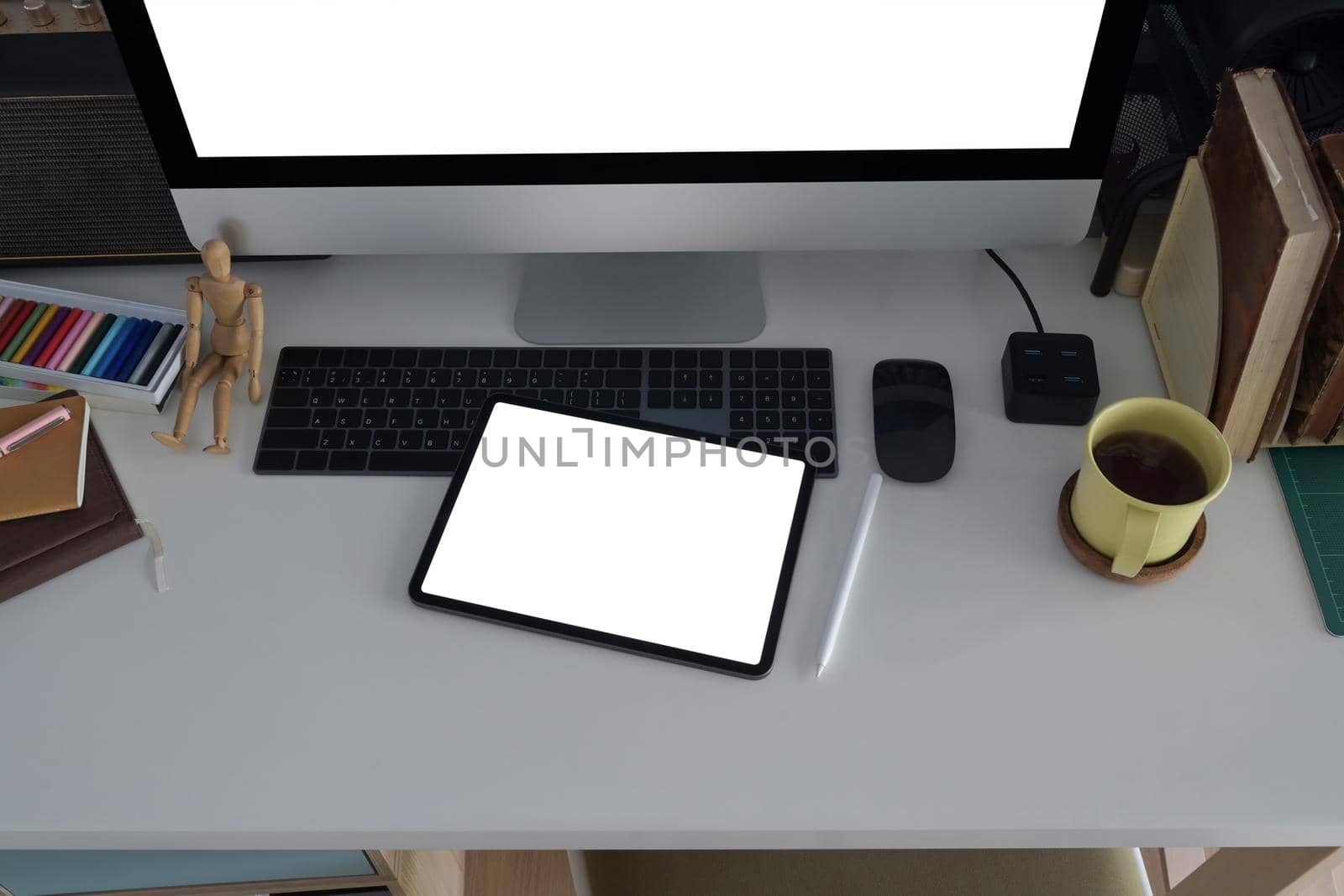 Creative designer workplace with digital tablet, computer, coffee cup and stationery on white table.